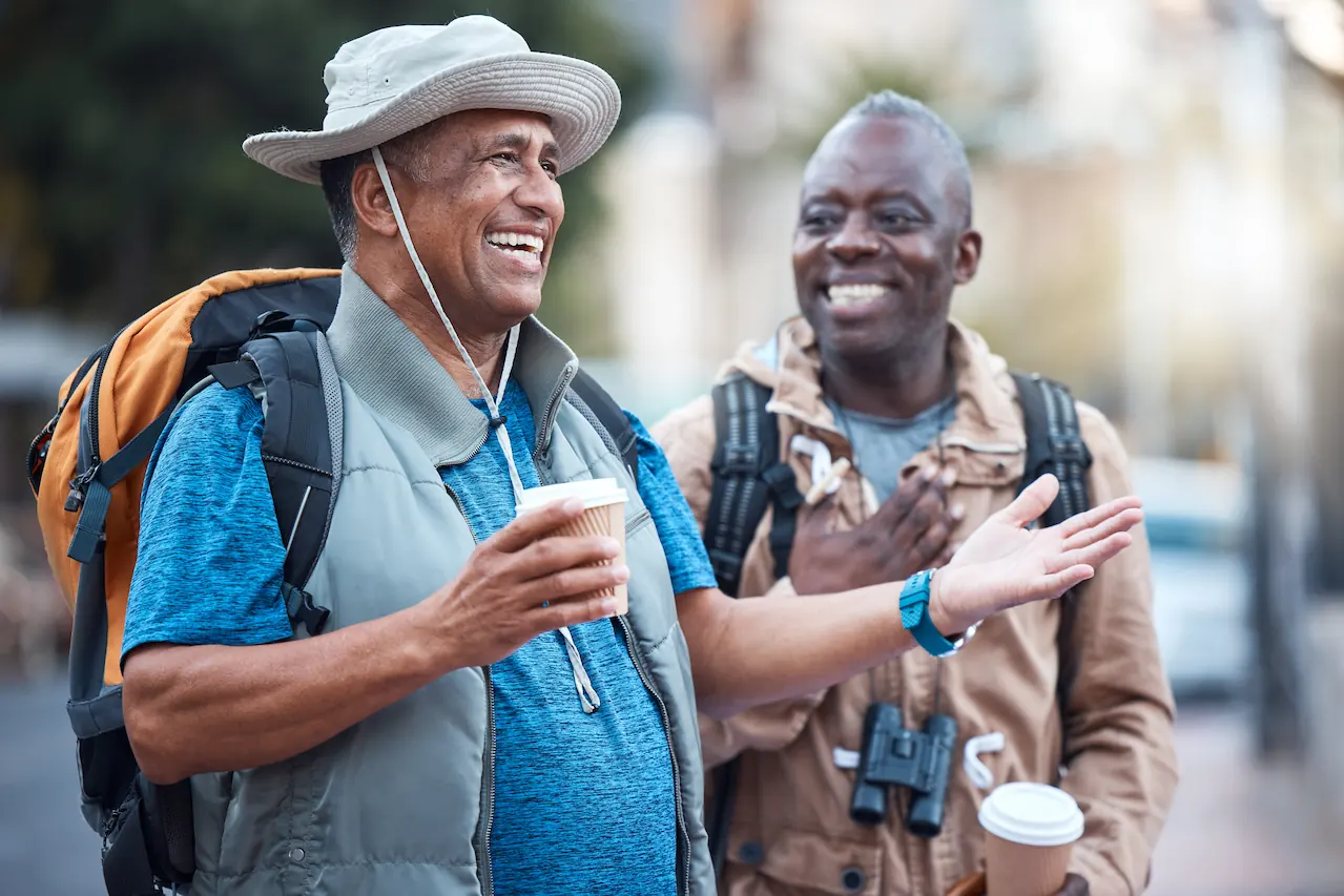 Two men talking to each other while standing on a sidewalk